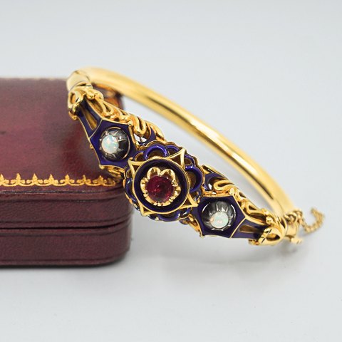 Bangle of 18k gold set with opal, a ruby, and blue enamel, 19th century Bangle of 18k gold set with opal, a ruby, and blue enamel, 19th century